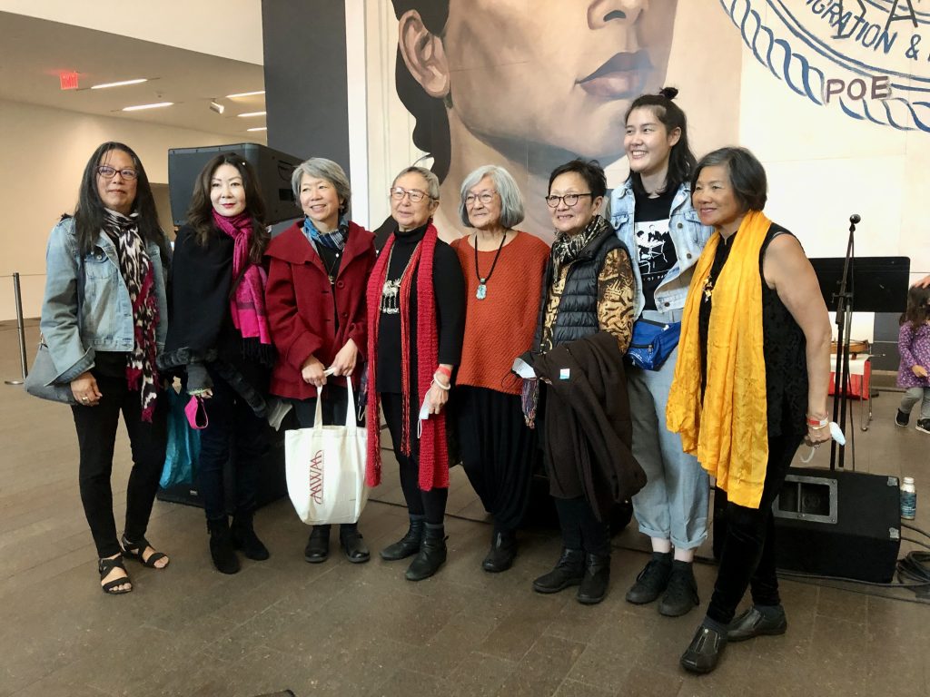 Eight Asian American women artists from AAWAA, the Asian American Women Artists Association, gather in front of Hung Liu’s mural, Resident Alien, after The Last Hoisan Poets tribute to the artist. 